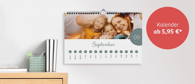 Ein individuell gestalteter Fotokalender hängt an der Wand und zeigt ein Familienfoto auf einem Kalenderblatt.