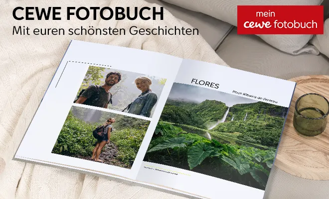 Offenes Fotobuch mit Urlaubs- und Naturbildern, daneben ein grünes Trinkglas und eine bequeme Decke.