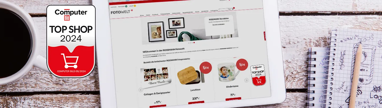Unsere Website auf einem Tablet mit der Top Shop 2024 Auszeichnung von Computer Bild, daneben eine Tasse Kaffee und Notizbücher.