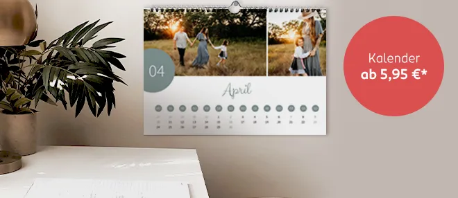 Ein individuell gestalteter Fotokalender hängt an der Wand und zeigt ein Familienfoto auf einem Kalenderblatt.