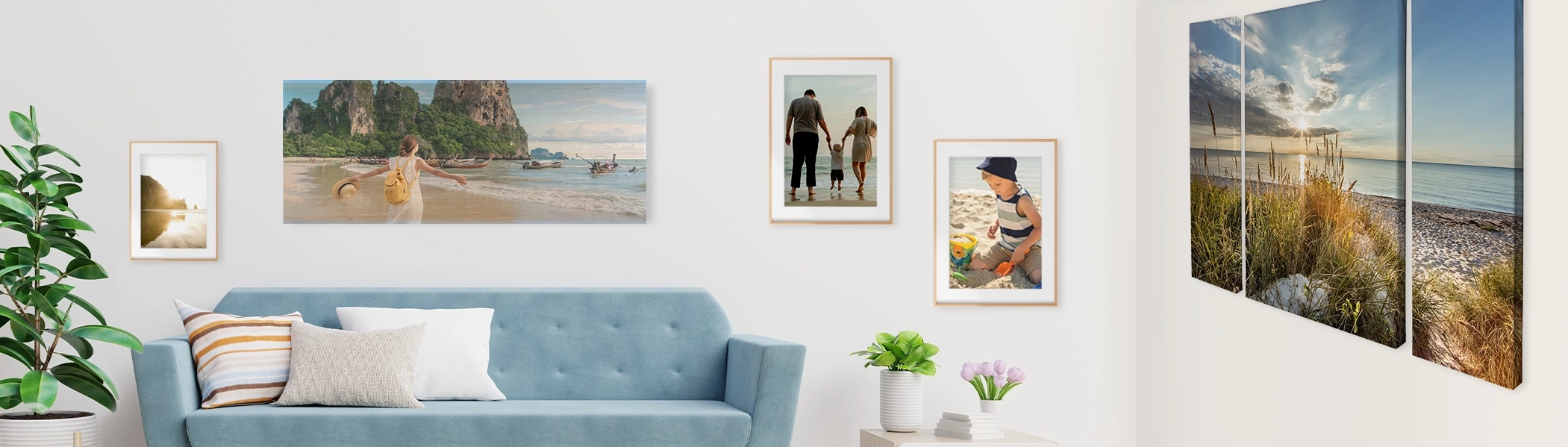 Wohnzimmerszene mit unterschiedlichen Wandbildern, über blauer Couch großes Foto auf Holz, links und rechts daneben gerahmte Poster, Mehrteilige Leinwand auf der rechten Seite mit Strandmotiv