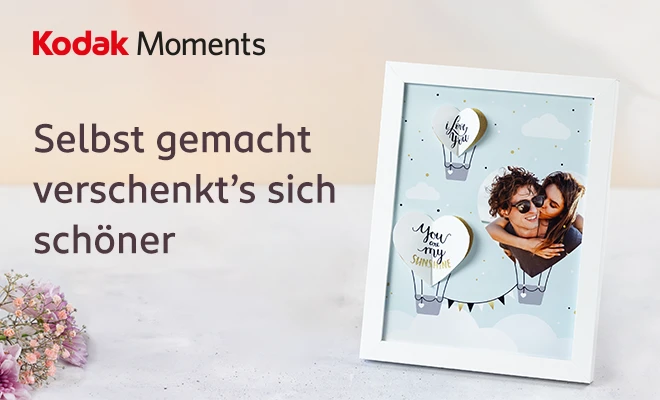 Ein selbstgemachter Bilderrahmen mit einem Paar und liebevollen Schriftzügen auf Wolken.
