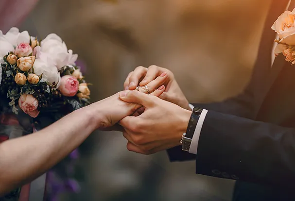 Ein paar Hände steckt einem anderen einen Ehering an. In der Hochzeitswelt findet ihr personalisierte Foto-Geschenke zur Hochzeit.