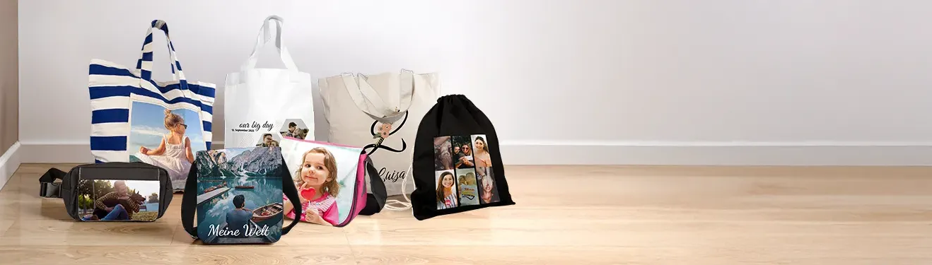 Auf einem Holzfußboden sind bedruckte Taschen und Beutel der ROSSMANN Fotowelt zu sehen.