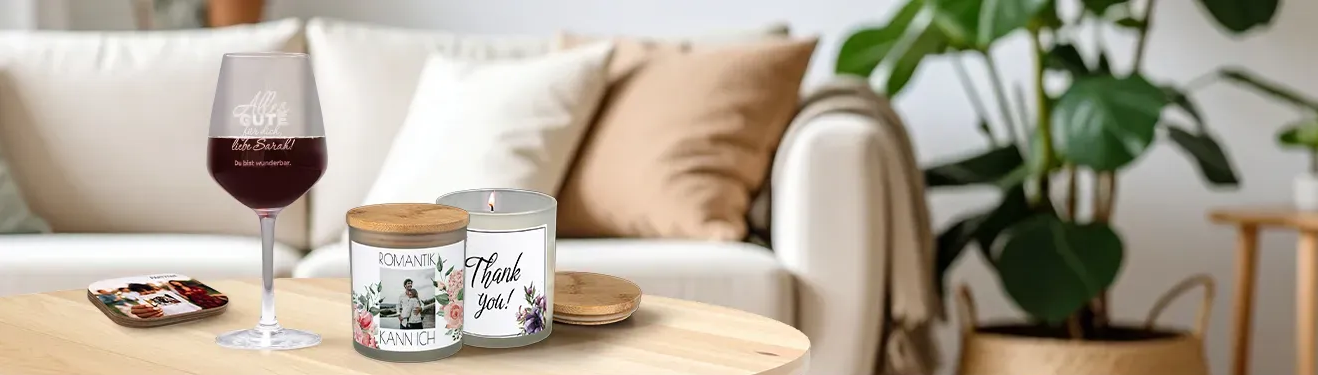Vor einem Sofa stehe ein Tisch. Darauf finden sich bedruckte Fotogeschenke wie Gläser und Kerzen.