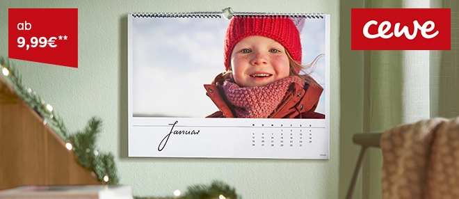 Wandkalender mit Kalendermonat Januar aufgehängt an grüner Wohnwand. Daruf ein Foto mit Kind und rotem Winteranzug, Mütze und Schal