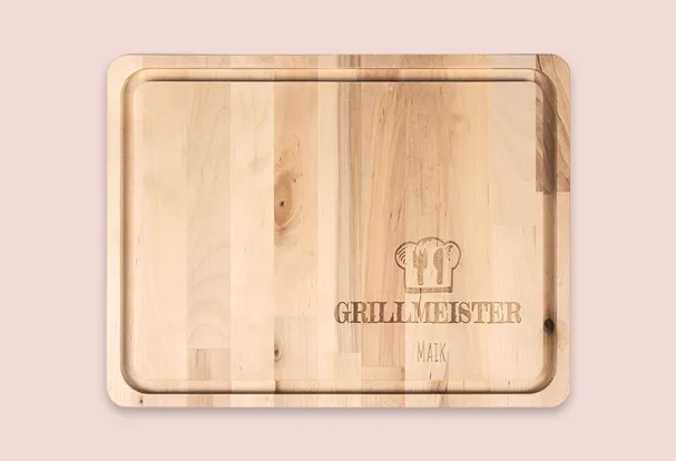 Holzschneidebrett mit eingefräster Rille und graviertem Schriftzug „Grillmeister Maik“, ideal als personalisiertes Geschenk.