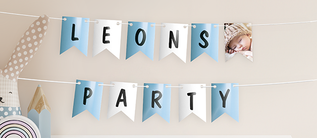 Eine blau-weiße Girlande mit dem Schriftzug "Leons Party" und einem Foto eines schlafenden Kindes.