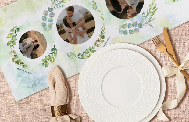 Personalisierter Tischläufer mit runden Familienfotos und grünen Blättern, umgeben von Geschirr, ergänzt die Hochzeitsplanung stilvoll.