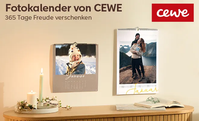 CEWEFotokalender - 2 Kalender hängen an der Wand über einem weihnachtlich dekoriertem Sideboard. Winterliche Motive sind auf den Kalenderblättern zu sehen.
