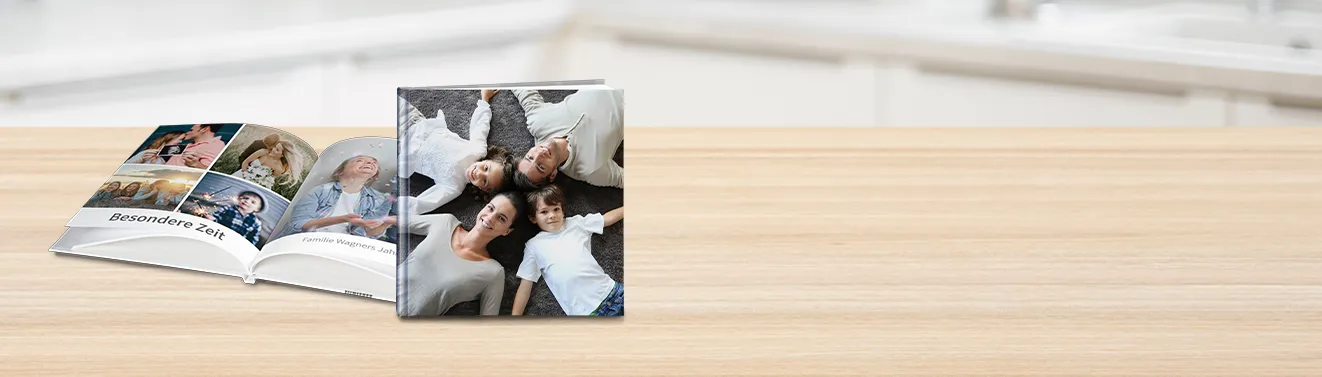 Ein aufgeschlagenes Fotobuch mit fröhlichen Momentaufnahmen. Haltet eure schönsten Fotos in einem Fotobuch fest.