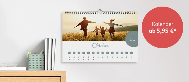 Ein individuell gestalteter Fotokalender hängt an der Wand und zeigt ein Familienfoto auf einem Kalenderblatt.