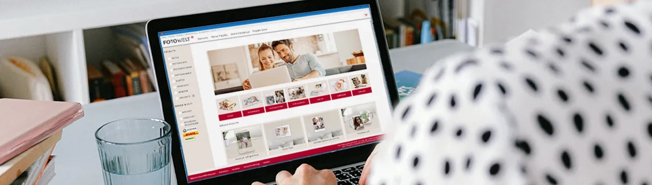 Eine Person nutzt die ROSSMANN Fotobuch Software auf einem Laptop, um Fotoprodukte wie Bücher und Kalender zu gestalten.