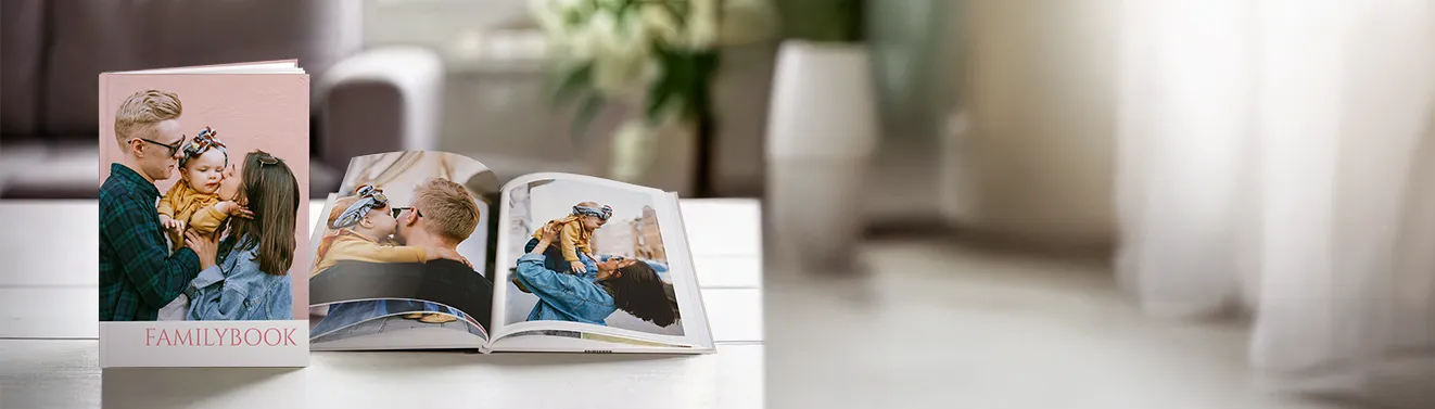 Ein aufgeschlagenes Fotobuch mit fröhlichen Momentaufnahmen. Haltet eure schönsten Fotos in einem Fotobuch fest.