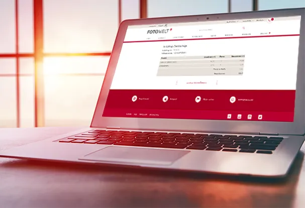 Ein geöffneter Laptop zeigt eine Benutzeroberfläche zur Überprüfung des Auftragsstatus bei Sonnenuntergang im Hintergrund.