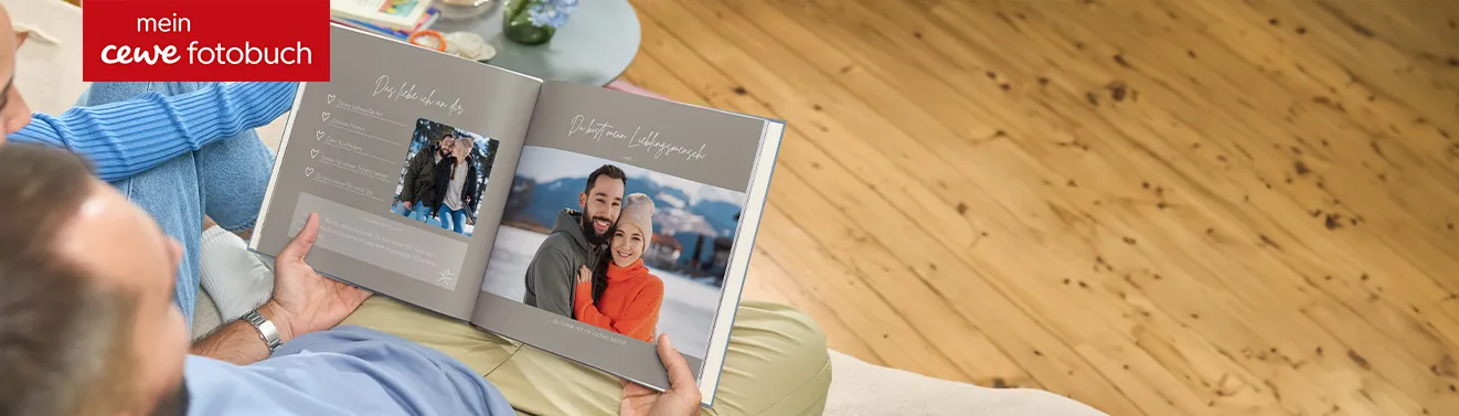 Fotobuch von Cewe 2 Personen schauen sichein aufgeschlagenes Fotobuch mit gemeinsamen Erinnerungsfotos an
