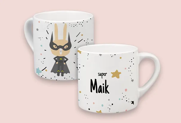 Weiße Kindertasse mit fantasievollem Superhelden-Hasenmotiv und Namen „Maik“ in einem farbenfrohen Design.