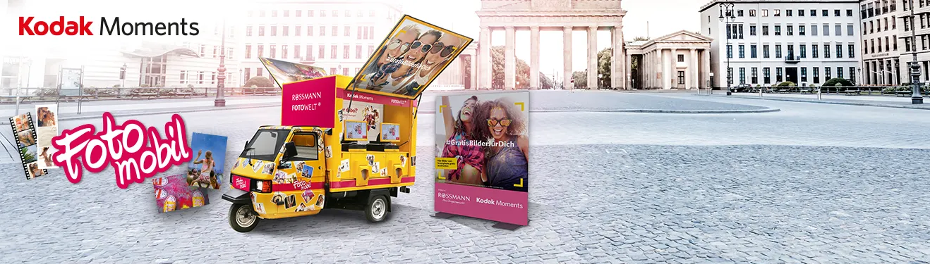 Ein auffälliger mobiler Fotowagen in einer Stadt, bietet schnelle Fotoabzüge mit buntem Design.