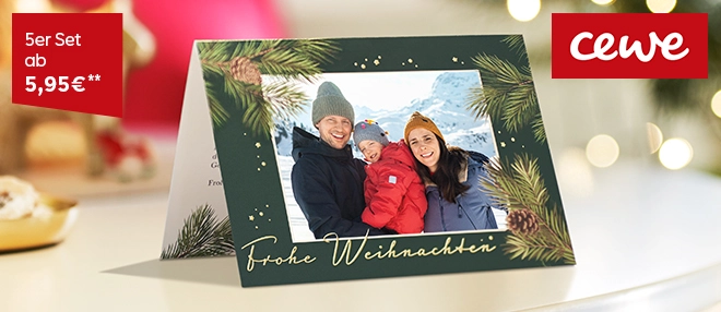 Klappgrußkarte aufgestellt auf weihnachtlich geschmücktem Tisch mit Weihnachtsgrüßen.