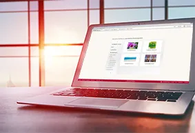 Laptop mit der geöffneten ROSSMANN Fotowelt-Software zeigt Auswahlmöglichkeiten für personalisierte Fotoprodukte.