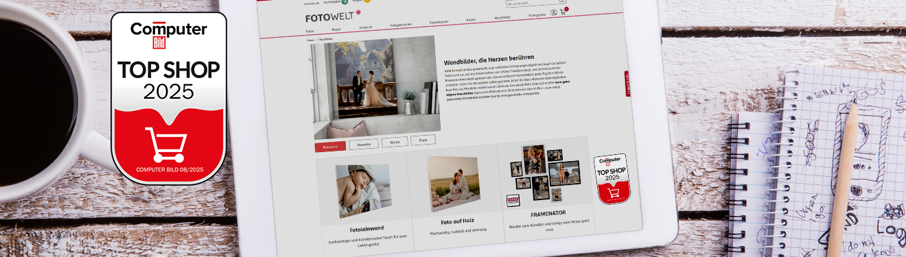 Unsere Website auf einem Tablet mit der Top Shop 2025 Auszeichnung von Computer Bild, daneben eine Tasse Kaffee und Notizbücher.