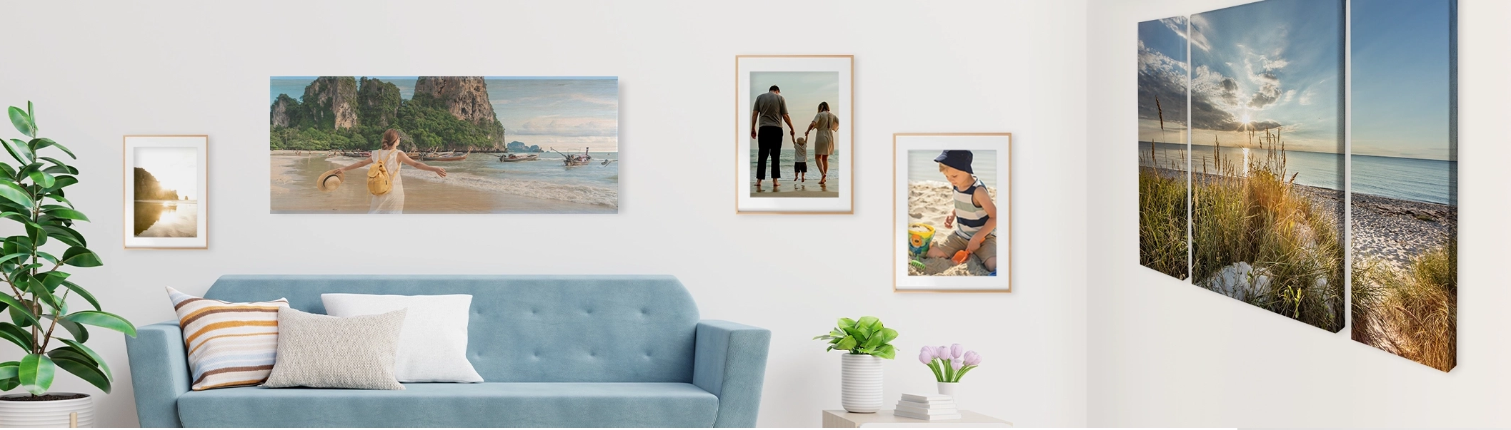 Wohnzimmerszene mit unterschiedlichen Wandbildern, über blauer Couch großes Foto auf Holz, links und rechts daneben gerahmte Poster, Mehrteilige Leinwand auf der rechten Seite mit Strandmotiv