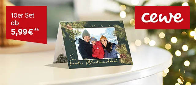 Klappgrußkarte aufgestellt auf weihnachtlich geschmücktem Tisch mit Weihnachtsgrüßen.