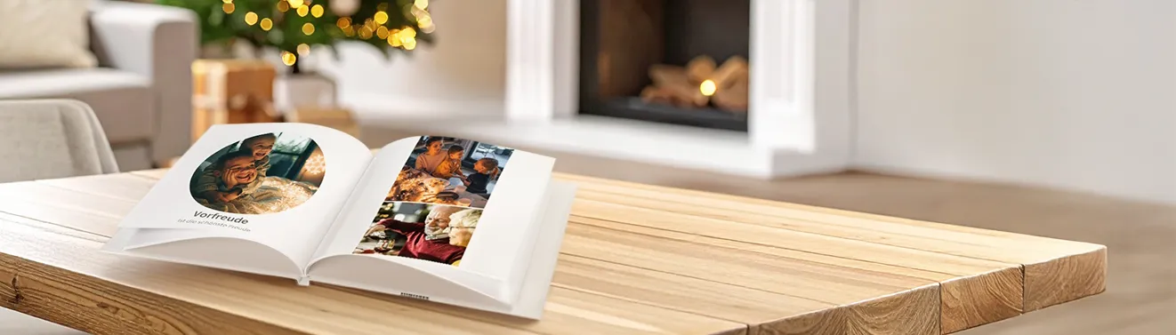 Ein aufgeschlagenes Fotobuch mit fröhlichen Momentaufnahmen. Haltet eure schönsten Fotos in einem Fotobuch fest.