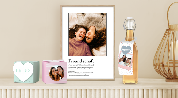 Eine Sammlung von gerahmten XL-Fotos, Geschenkbox und einer personalisierten Weinflasche.
