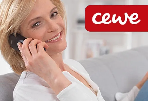 Frau telefoniert lächelnd im Zusammenhang mit einer Cewe Fotobestellung