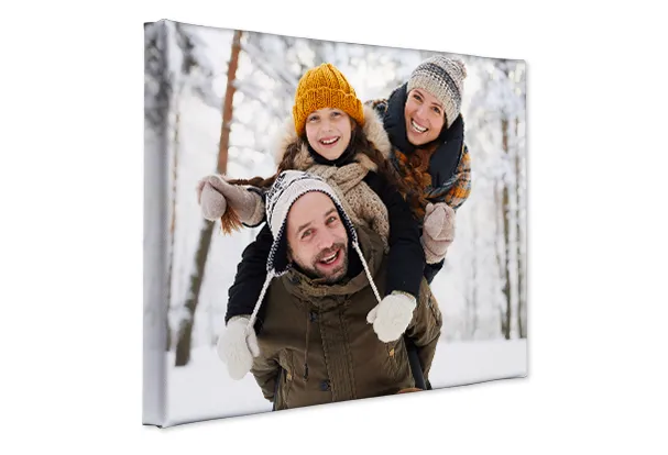 Wandbilder mit eigenen Fotos gestalten – persönliche Erinnerungen auf Leinwand Fotoleinwand mit winterlichem Familienfoto von Eltern und Kind im verschneiten Wald