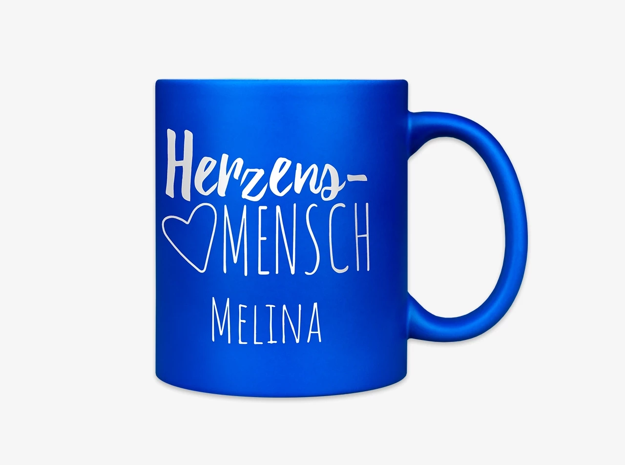 Eine farbige Tasse mit Gravur, die das Wort "Herzensmensch" und den Namen Melina in einem modernen Schriftstil zeigt.
