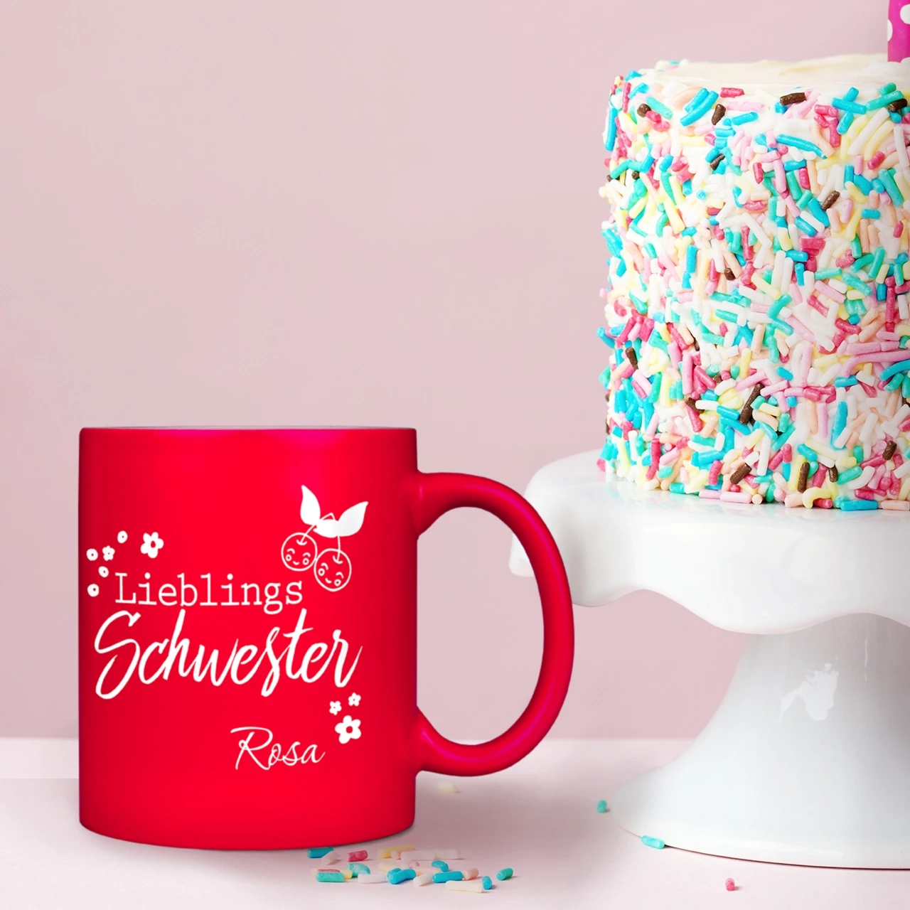 Eine pinke Tasse mit Gravur, die das Wort Lieblingsschwester und den Namen Rosa mit charmanten Details zeigt.
