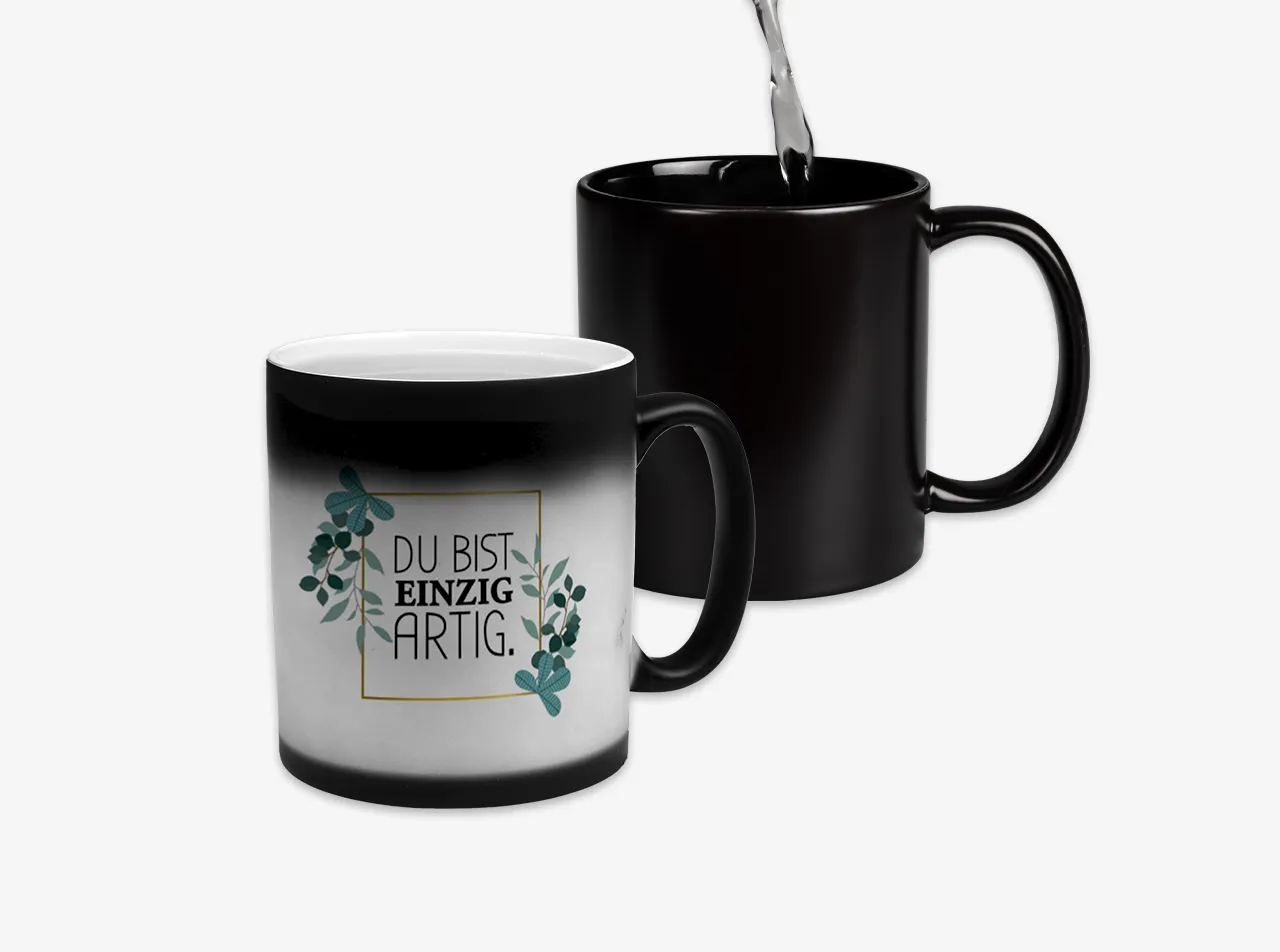 Eine komplett schwarze Zaubertasse und eine schwarze Tasse mit weißer Innerfarbe, die bei Wärme ein individuelles Design zeigt.
