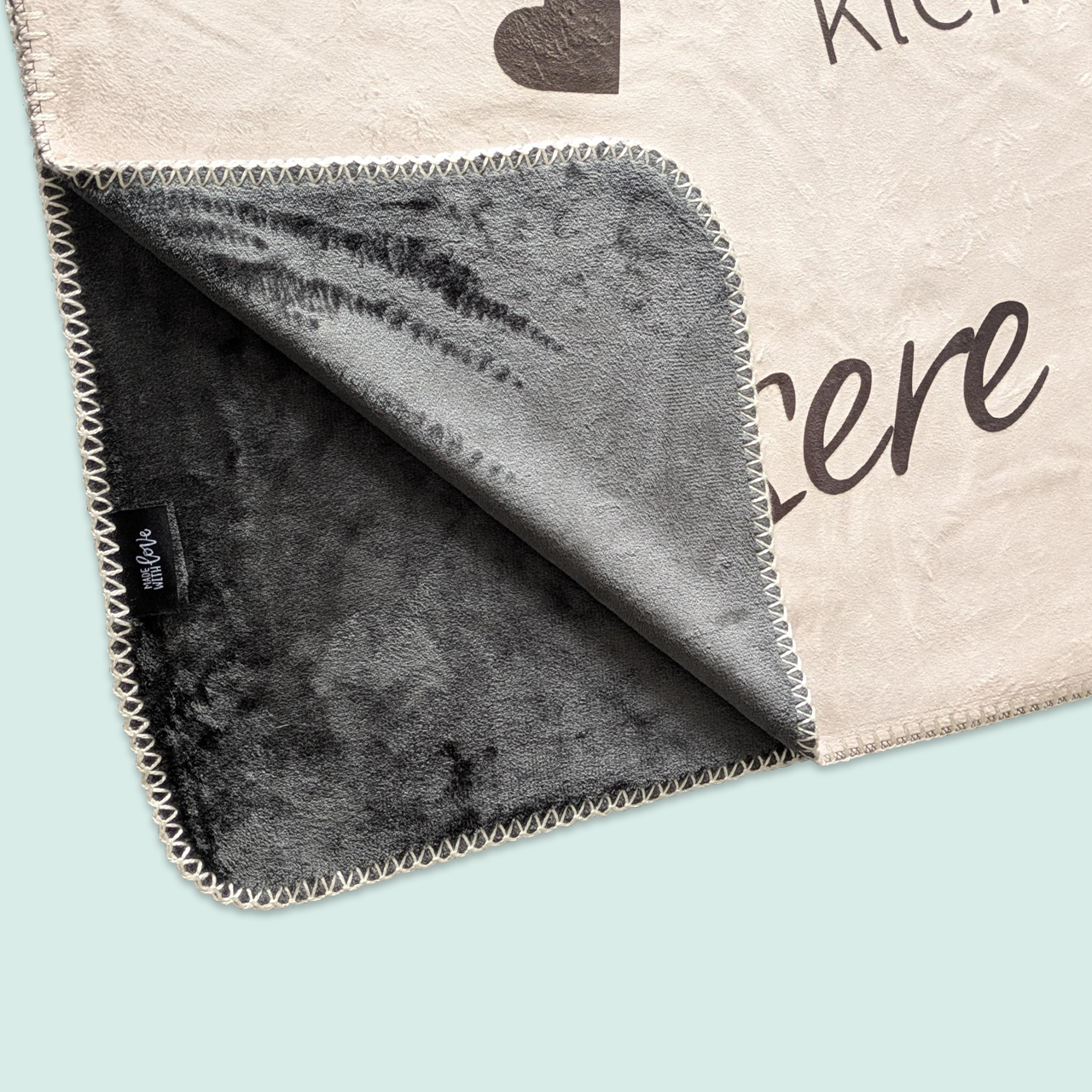 Detailansicht der Premium Kuscheldecke mit weicher anthrazitfarbener Rückseite und feiner Naht